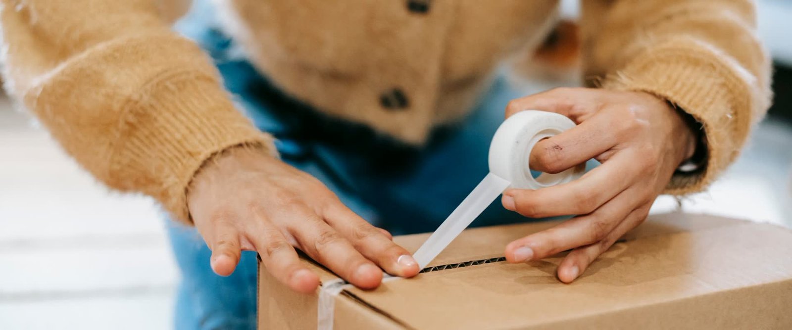 A parcel box being taped and sealed ahead of being weighed and priced